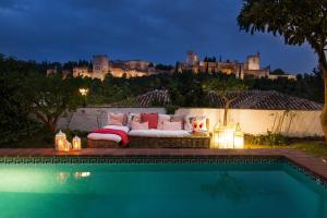 a couch sitting next to a pool with a castle at 2.5 Million Villa. Magical Sunset. Super close to everything. 5BR, 4BA, Pool, A/C+Heating in Granada