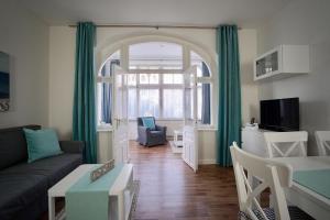 uma sala de estar com um sofá e uma mesa em Jasmund-04-Ferienwohnung-bis-6-Personen-Wohng-4 em Ostseebad Sellin