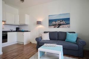 sala de estar con sofá azul y mesa en Jasmund-04-Ferienwohnung-bis-6-Personen-Wohng-4 en Ostseebad Sellin