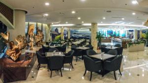 a restaurant with black chairs and tables in a room at Jeju Pacific Hotel in Jeju