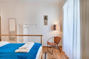 ein Schlafzimmer mit einem Bett, einem Stuhl und einem Fenster in der Unterkunft Spacious Bairro Alto Apartment With Courtyard, By TimeCooler in Lissabon