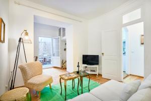 a living room with a white couch and a table at Spacious Bairro Alto Apartment With Courtyard, By TimeCooler in Lisbon