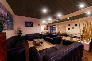 sala de estar con sofás de cuero y mesa en Motel Hotel Piranha, en Cameriano