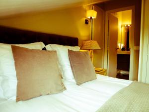 a bed with white sheets and pillows in a room at Apartamentos Formigal - admite mascotas in Formigal