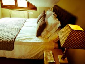 a bedroom with a bed with pillows and a lamp at Apartamentos Formigal - admite mascotas in Formigal