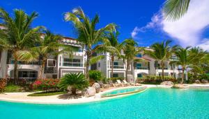 a resort with a swimming pool and palm trees at Atmospheric apartment with a beautiful view of the swimming pool in Bayahibe