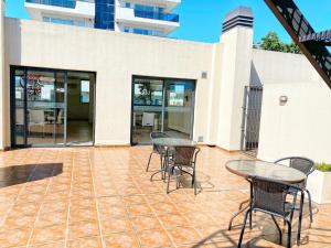 a patio with tables and chairs and a building at Constantino Iii in Villa Carlos Paz