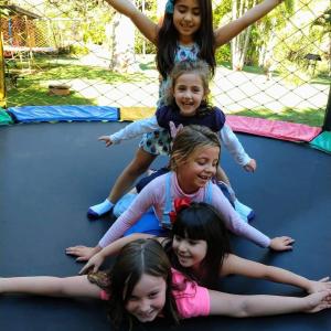 grupa dziewczyn bawiących się na trampolinie w obiekcie Hotel Fazenda Jacaúna w mieście Brotas