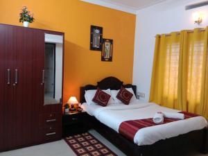 a bedroom with a bed and a dresser with a mirror at Coorg Homeland Homestay -With Kitchenette in Madikeri