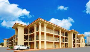 a building with a car parked in front of it at Fairway Inn in Fort Walton Beach