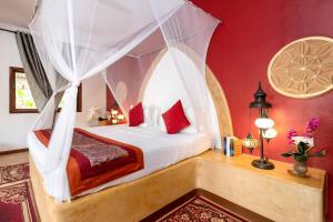 a bedroom with a bed with red walls at Natural Kendwa Villa in Kendwa