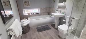 North ThoresbyにあるThe Saddlery Holiday Cottage - Near Wolds And Coastの浴槽、洗面台、トイレを備えたバスルーム +12枚の写真