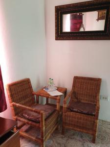 two chairs and a table in a room with a mirror at Polish Princess Guest House in Port Antonio