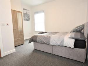 a bedroom with a bed and a window at Townhouse @ Birks Street Stoke in Stoke on Trent
