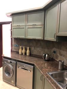 a kitchen with a sink and a washing machine at Byoum Vacation House in Fayoum Center