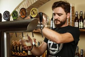 a man pours a drink into a glass at Podere I Massoni in Monterotondo