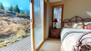 a bedroom with a bed and a sliding glass door at Snowcreek V #774 condo in Mammoth Lakes +24 photos