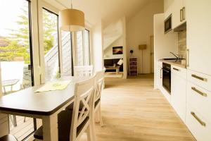 a kitchen and dining room with a table and chairs at Frau-Clara-Haus-Ecke-3 in Eckernförde