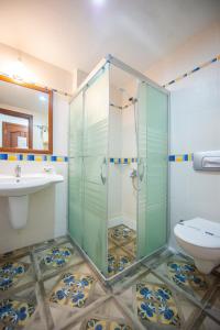 a bathroom with a glass shower and a toilet at White Hotel in Oludeniz