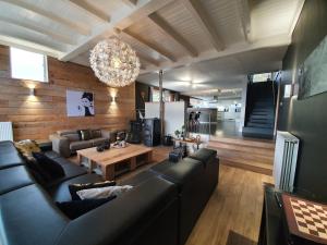 sala de estar con sofá negro y mesa en Gîte Le Rivage en Stavelot