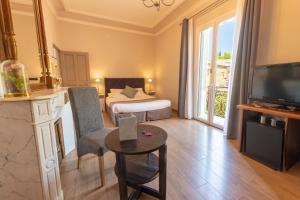 a hotel room with a bed and a television and a table at Hotel Sainte Anne - Apt in Apt