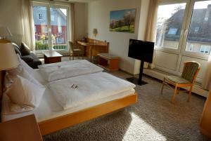 een slaapkamer met een bed en een woonkamer bij Engelberg 24h check in in Wangen im Allgäu