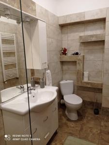 a bathroom with a white sink and a toilet at Central View Piata Sfatului 7- Panoramic Apartment in Braşov +33 photos