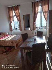 a bedroom with a dining room table and a bed at Central View Piata Sfatului 7- Panoramic Apartment in Braşov
