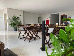 a restaurant with wooden tables and chairs and plants at Hotel Estrela de Minas in São Gabriel