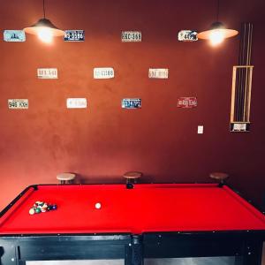 a red pool table in a room with signs on the wall at Pousada Boa Sorte in Cumuruxatiba +52 photos