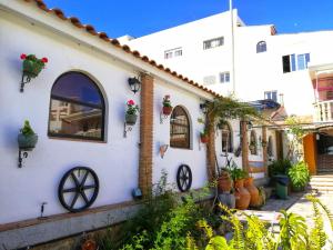une maison blanche avec des plantes sur son côté dans l'établissement Casa Proyecto Pepe Bravo - Arte de manos y corazón, à Alozaina