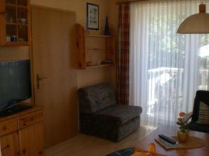 a living room with a chair and a television at Letztes Haus vorm Wasser (2) in Strukkamp auf Fehmarn