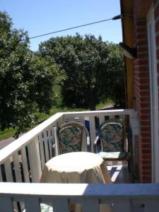 a white porch with a table and two chairs at Letztes Haus vorm Wasser (2) in Strukkamp auf Fehmarn