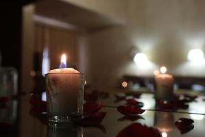 a candle sitting on a table with red roses at Casa de la Loma in Morelia