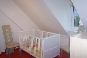 a white crib in a room with a window at Ferienwohnung-Familie-Hempel in Hohendorf
