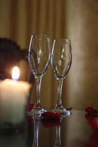 two wine glasses sitting on a table with a candle at Casa de la Loma in Morelia
