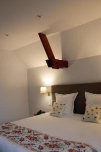 sypialnia z dużym łóżkiem z białą pościelą i poduszkami w obiekcie Hôtel Château de la Marlière w mieście Fourmies