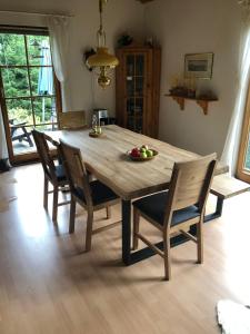 a wooden dining room table with chairs and a bowl of fruit on it at Waldhaeuschen in Bad Sachsa