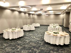 a row of tables with white table cloths in a room at Holiday Inn - NW Houston Beltway 8, an IHG Hotel in Houston