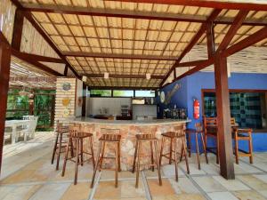 an outdoor kitchen with a bar with stools at Eco Resort Vento Leste in Jericoacoara
