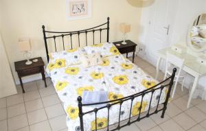 1 dormitorio con 1 cama con edredón amarillo y blanco en Wisteria Gite, en Asnières-sur-Vègre
