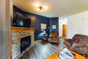 a living room with a fireplace and a flat screen tv at Condo 123 at Snowbridge in Blue Mountains