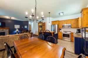 a kitchen and living room with a wooden dining table at Condo 123 at Snowbridge in Blue Mountains