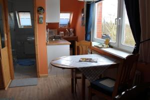 a small kitchen with a table and a sink at Googeswill-Wohnung-1 in Tinnum