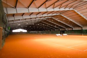 a tennis court with a person standing on it at Hotel Khail in Maria Lanzendorf