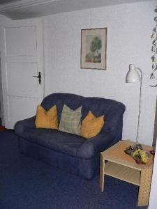 ein Wohnzimmer mit einem blauen Sofa und einem Tisch in der Unterkunft Apartment 2 in Schönhagen