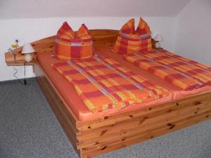 a wooden bed with two pillows on top of it at Apartment-2 in Schönhagen