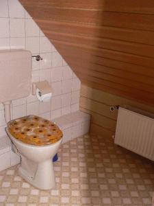 a bathroom with a toilet with a wooden lid at Apartment-2 in Schönhagen