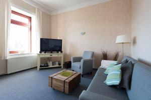ein Wohnzimmer mit einem Sofa und einem TV in der Unterkunft Kapitänshaus Lassen - Zimmer Penelope in Westerland