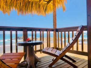 a table and a chair on a porch with the beach at Hotel Paraíso del Pescador by Rotamundos in San Agustinillo